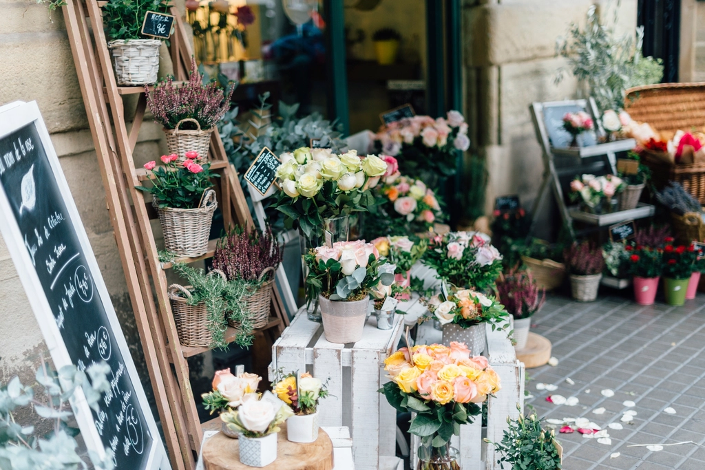 Buckets and baskets of fresh flowers outside a small flower shop